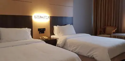 a hotel room with two beds and a telephone at Ariston Hotel Bangkok in Bangkok