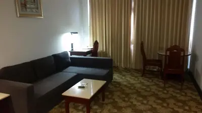 a living room with a couch and a table at Ariston Hotel Bangkok in Bangkok