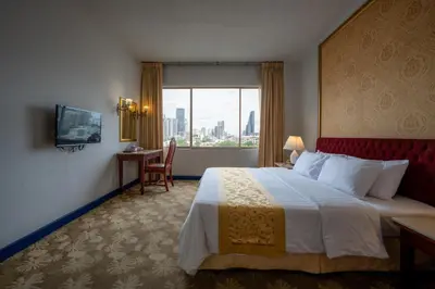 a hotel room with a large bed and a window at Ariston Hotel Bangkok in Bangkok