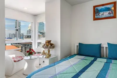 a bedroom with a bed and a large window at Parvena Hotel Sathorn in Bangkok