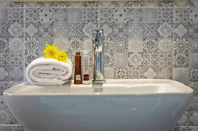 a bathroom sink with a towel and a faucet at Casa Residence Hotel in Bangkok