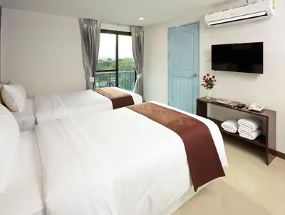 a hotel room with two beds and a television at Casa Residence Hotel in Bangkok