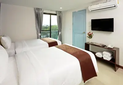 a hotel room with two beds and a television at Casa Residence Hotel in Bangkok