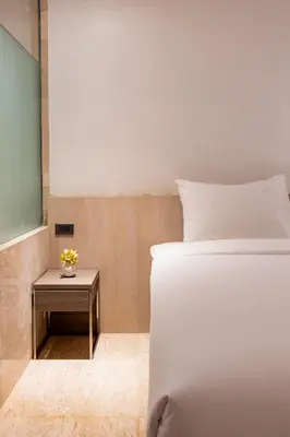 a bedroom with a white bed and a table at Sukhothai Residence Ruam Ruedi in Bangkok