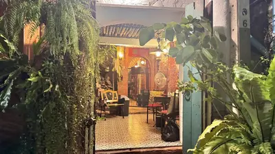 a view of a hallway with plants and a house at Café de Baan Raow in Bangkok
