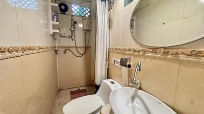 a bathroom with a toilet and a sink and a mirror at Café de Baan Raow in Bangkok