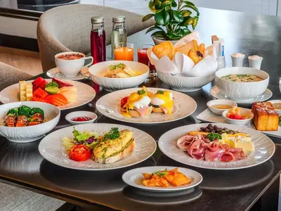 a table with many plates of food on it at Marriott Executive Apartments Bangkok, Sukhumvit 50 in Bangkok