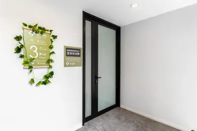 an open door with a sign on a wall at Nest by Sangob in Bangkok