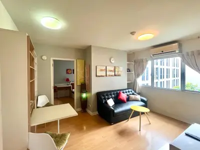 a living room with a couch and a table at 1BR Condo 5 Min to BTS 1000Mbps Fiber Wi-Fi great location in Bangkok