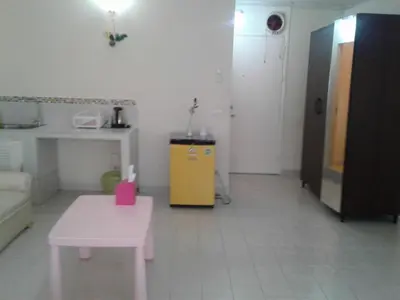 a room with a pink table and a yellow cabinet at IMPACT Challenger Muang Thong Thani Service Apartment in Bangkok