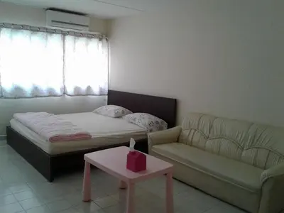 a bedroom with a bed and a couch and a table at IMPACT Challenger Muang Thong Thani Service Apartment in Bangkok