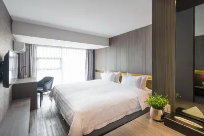 a bedroom with a large white bed and a desk at Fyn Hotel in Bangkok