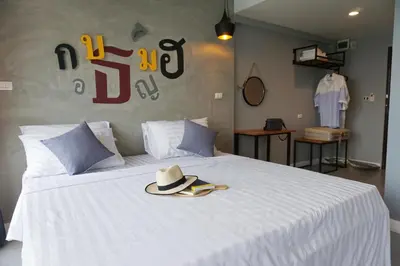 a white bed with a hat on top of it at Hansa Bangkok House in Bangkok