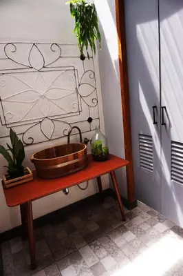 a wooden sink on a table next to a door at Hansa Bangkok House in Bangkok