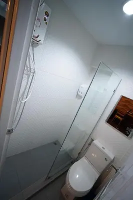 a bathroom with a toilet and a glass shower at Urban Hostel Bangkok in Bangkok
