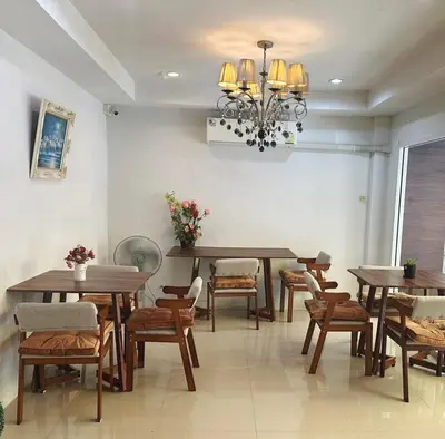 a dining room with tables and chairs and a chandelier at Bann Bunga Inn in Bangkok