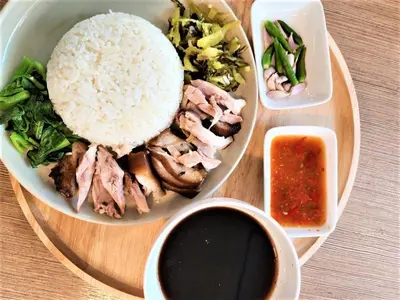 a plate of food with rice and meat and vegetables at Bangkok Loft Inn in Bangkok