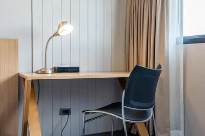 a desk with a chair and a lamp at Naga Residence in Bangkok