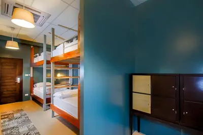 a bedroom with bunk beds and a blue wall at Hom Hostel & Cooking Club in Bangkok