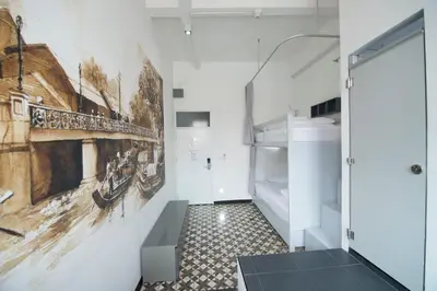 a hallway with a painting on the wall at Cacha Bed in Bangkok