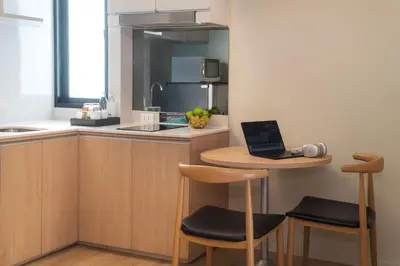 a kitchen with a small table with a laptop on it at Cross Vibe Bangkok Sukhumvit in Bangkok