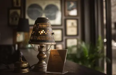 a lamp sitting on a table next to a cup at Heyyyy Bangkok in Bangkok