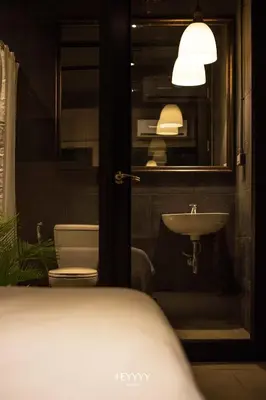 a bathroom with a sink and a toilet and a mirror at Heyyyy Bangkok in Bangkok