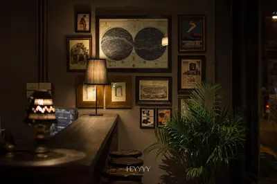 a room with a desk with a lamp and pictures on the wall at Heyyyy Bangkok in Bangkok