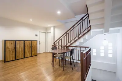 a dining room with a table and a staircase at X9Hostel in Bangkok