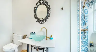a bathroom with a sink and a mirror at Baankachitpan Bangkok Hotel in Bangkok