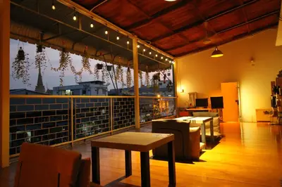 a restaurant with a table and a view of a city at Baan Nampetch Hostel in Bangkok