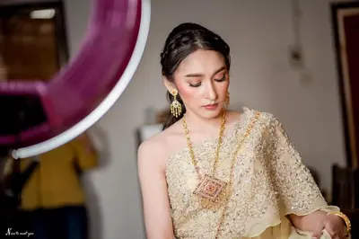 a woman is looking at herself in a mirror at Naturbliss Resort Village in Bangkok