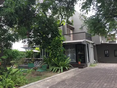 a house with green chairs and a patio at Baan Ongkharak bed & breakfast in Bangkok