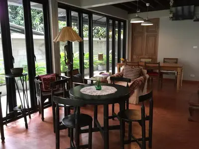 a living room with a table and chairs and a couch at Baan Ongkharak bed & breakfast in Bangkok