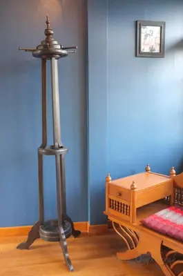 a room with a wooden table and a metal pole at Baan Ongkharak bed & breakfast in Bangkok