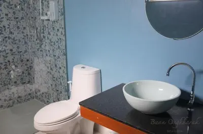 a bathroom with a toilet and a bowl on a counter at Baan Ongkharak bed & breakfast in Bangkok