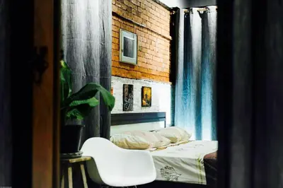 a bedroom with a bed and a white chair at Popcorn House Ratchada in Bangkok