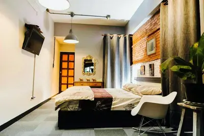 a bedroom with a bed and a chair in it at Popcorn House Ratchada in Bangkok
