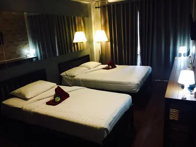 two beds in a hotel room with towels on them at Popcorn House Ratchada in Bangkok