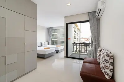 a living room with a couch and a window at Leenova Hotel in Bangkok