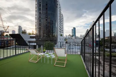 a balcony with chairs and a view of a city at BoB Hostel บ็อบโฮสเทล in Bangkok