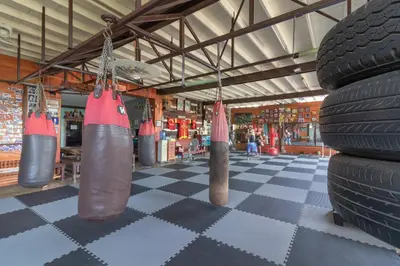 a gym with lots of tires on a checkered floor at Sor Vorapin Muay Thai Home in Bangkok