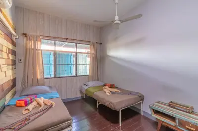 a room with two beds and a window at Sor Vorapin Muay Thai Home in Bangkok