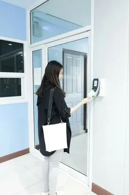 a woman is putting her cell phone into a door at โรงแรม เดอะริช ราชพฤกษ์ โฮเทล แอนด์ เรสซิเดนซ์ in Nonthaburi
