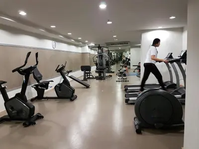 a woman running on a treadmill in a gym at Rich Park@Tao poon interchange in Bang Su