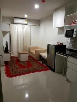a living room with a couch and a kitchen at Rich Park@Tao poon interchange in Bang Su