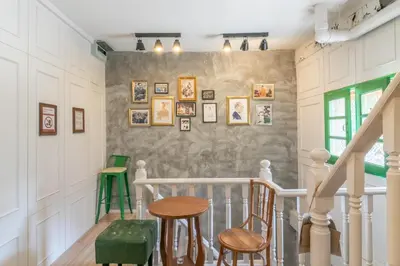 a staircase with chairs and a table in a house at Ratana Boutique Hostel in Bangkok