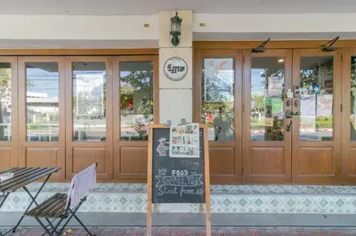 a restaurant with a sign in front of a building at Ratana Boutique Hostel in Bangkok