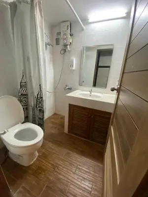 a bathroom with a toilet and a sink and a mirror at Augusta in Bangkok