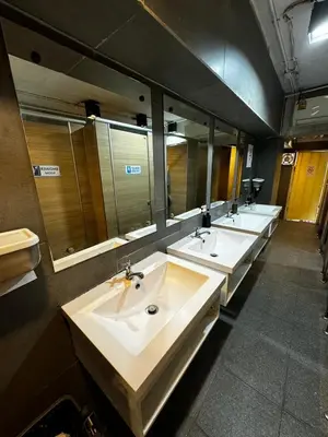 a bathroom with four sinks and a row of mirrors at Glur Central Pratunam in Bangkok